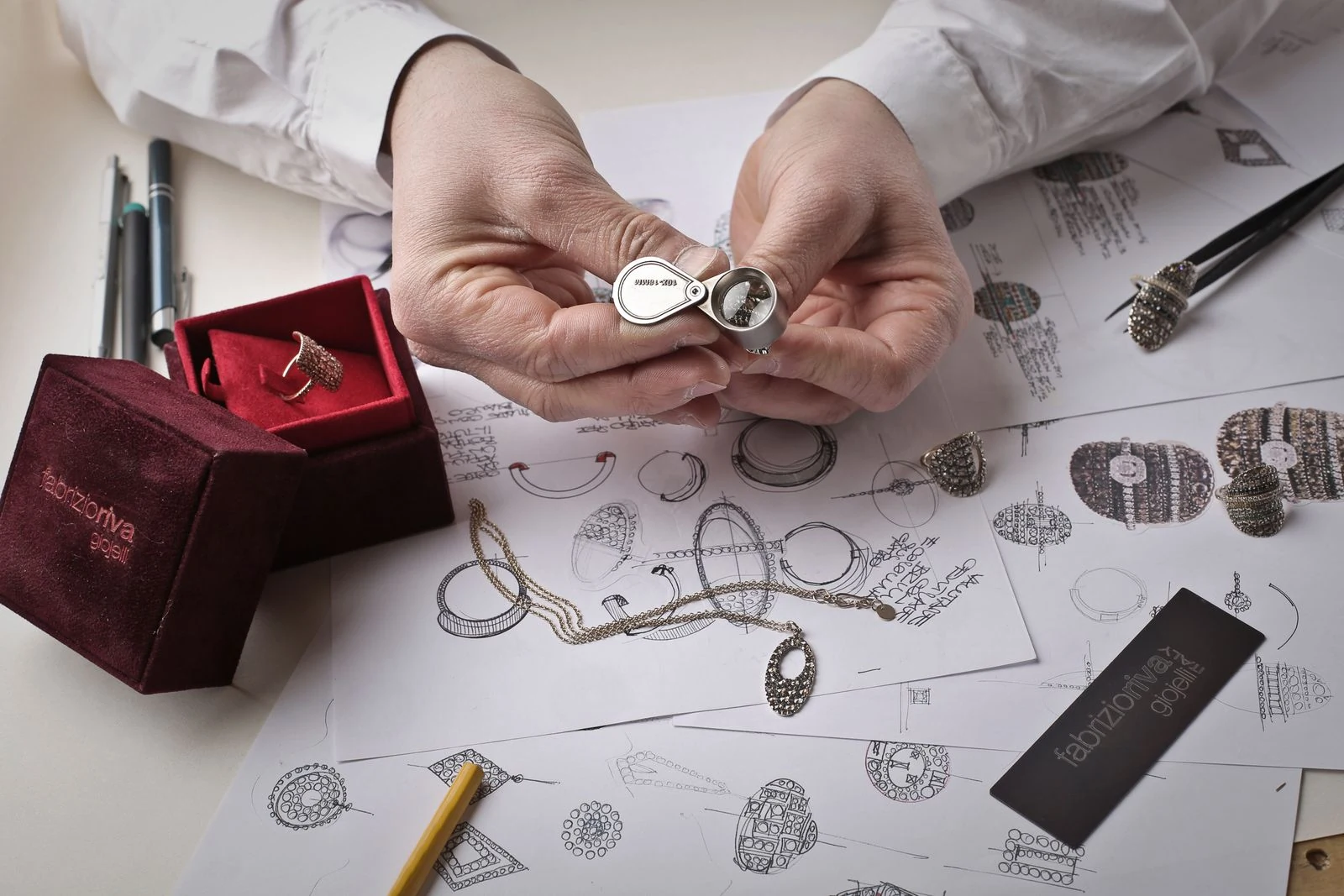 Jeweller inspecting a diamond ring with a loupe at a workbench