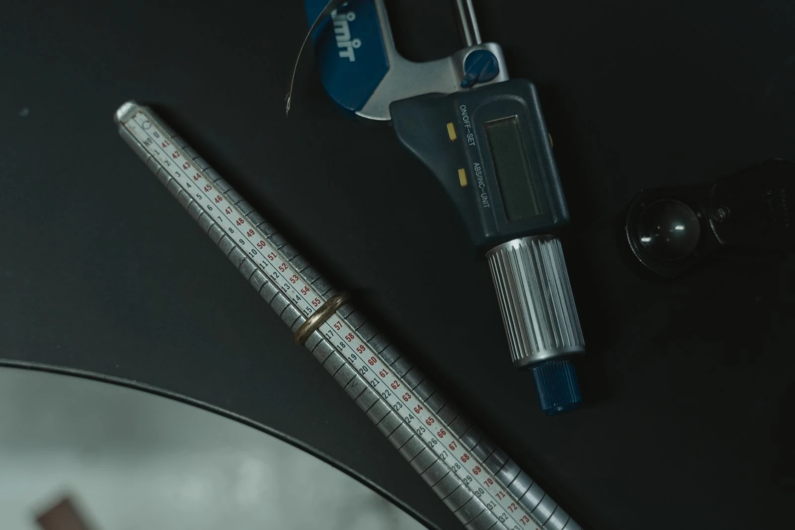 Jeweller ring sizer and digital calipers on a workbench